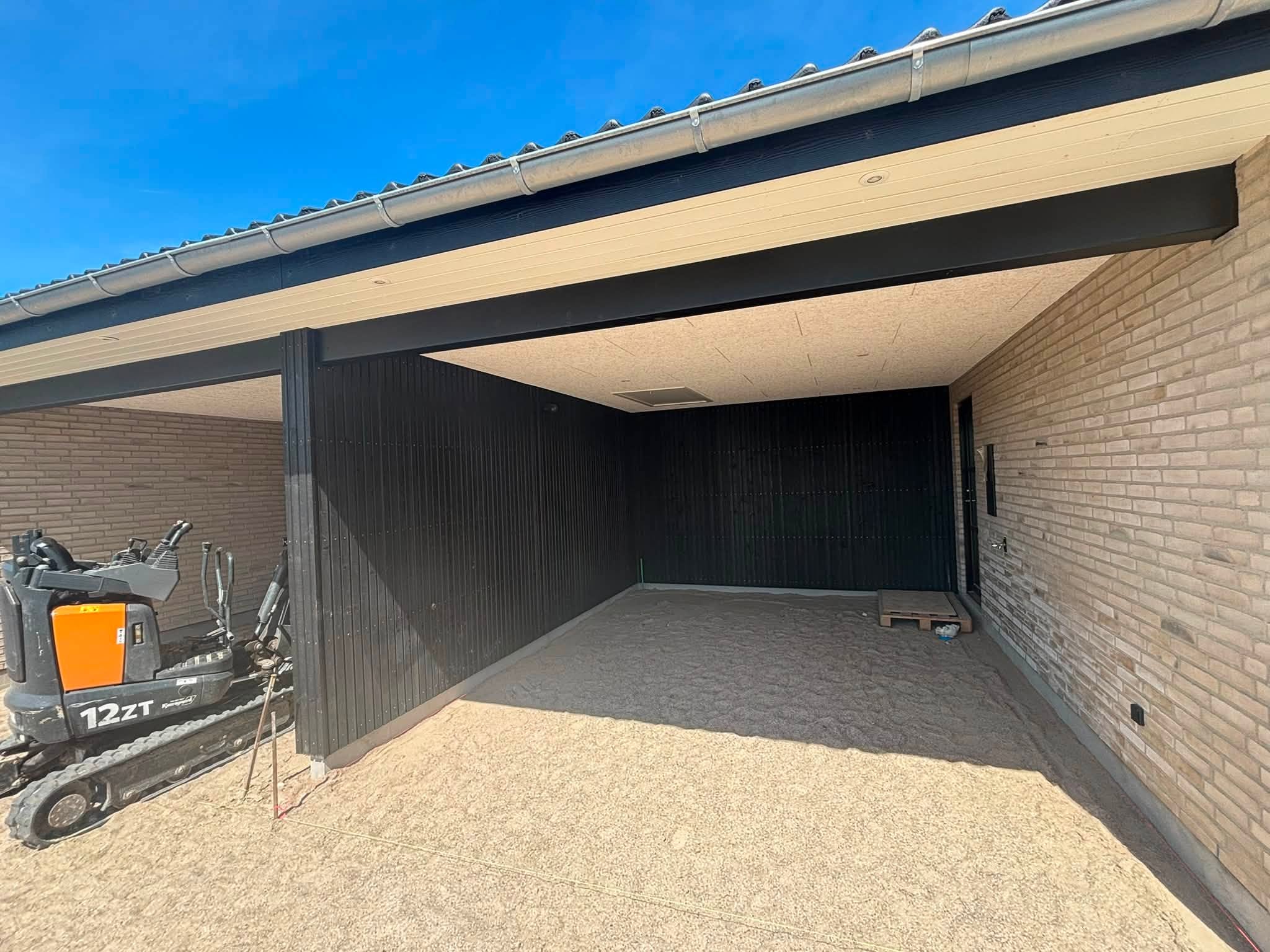 Sort carport med lyst træloft og skarpe samlinger